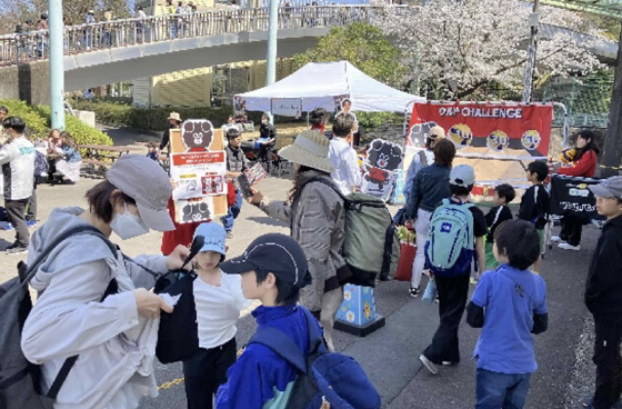 スポーツ体験ブースでバレーボール体験に集まる家族