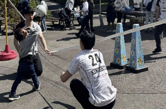 スポーツ体験ブースでバレーネットを前にする選手と子ども