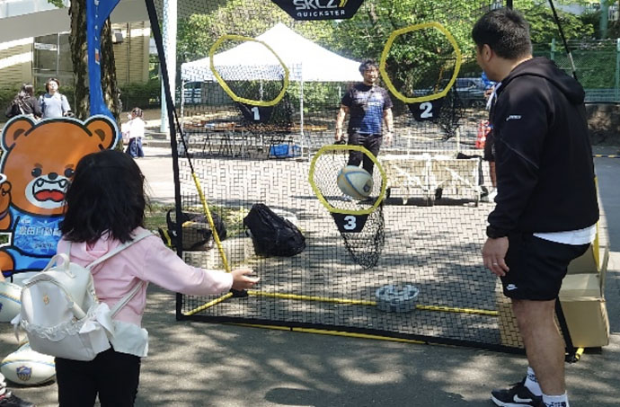 スポーツ体験ブースでラグビーボールを投げ込む様子