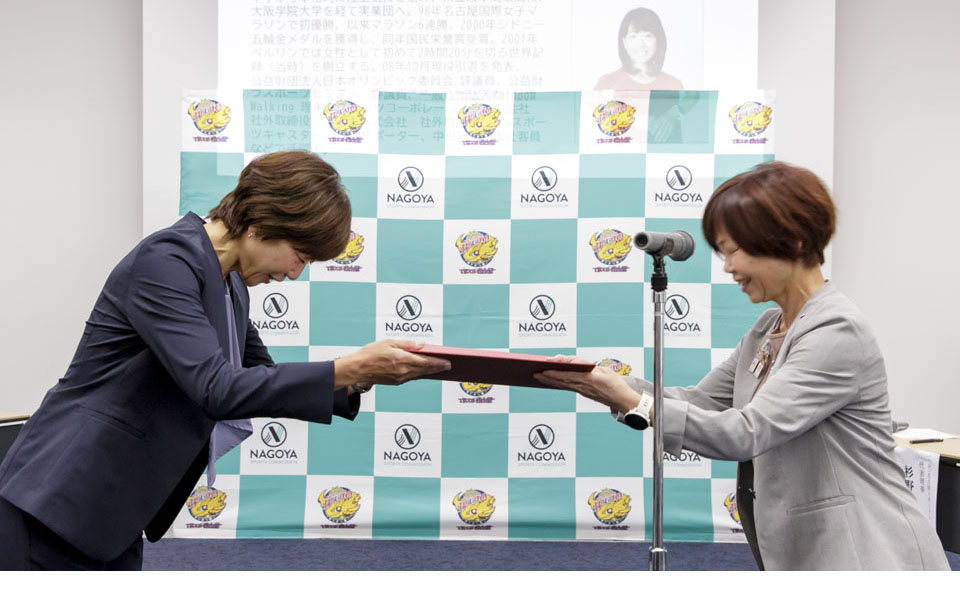 杉野副市長から高橋尚子氏へ一般社団法人名古屋スポーツコミッションの新会長就任の書類を渡している様子