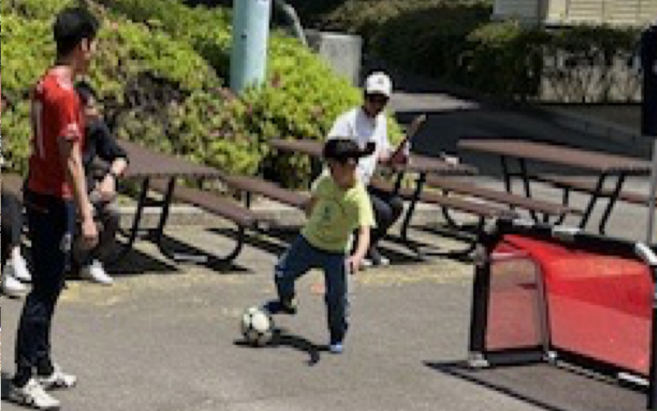 スポーツ体験ブースでボールをキープする子ども