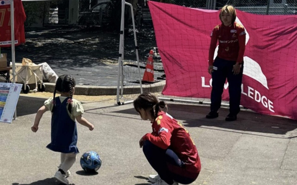 スポーツ体験ブースでシュートしようとする子ども