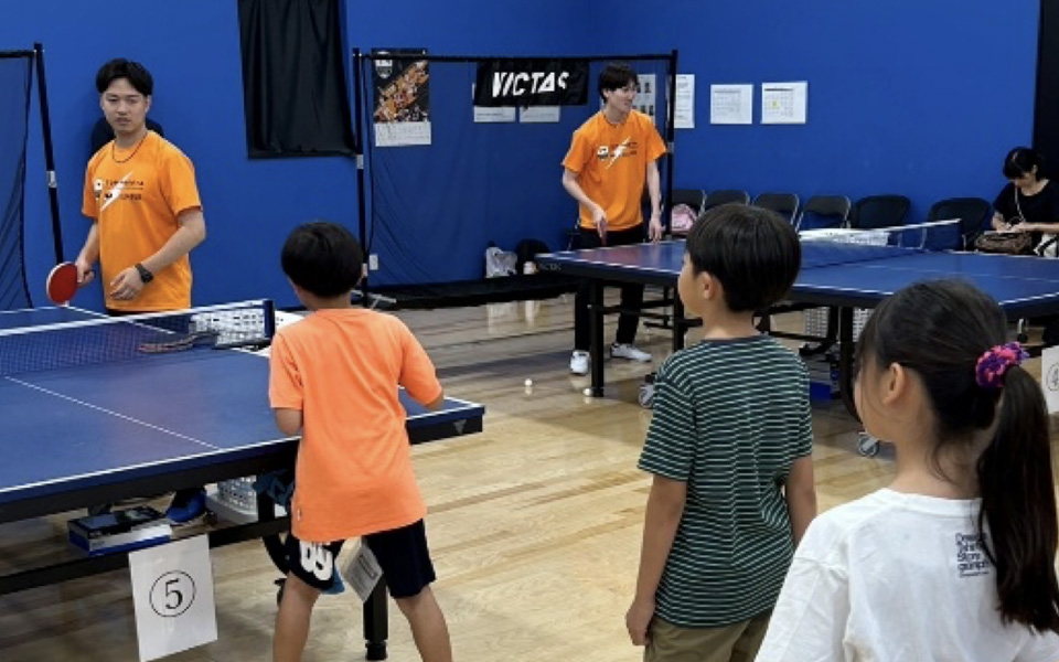 卓球台で練習する小学生