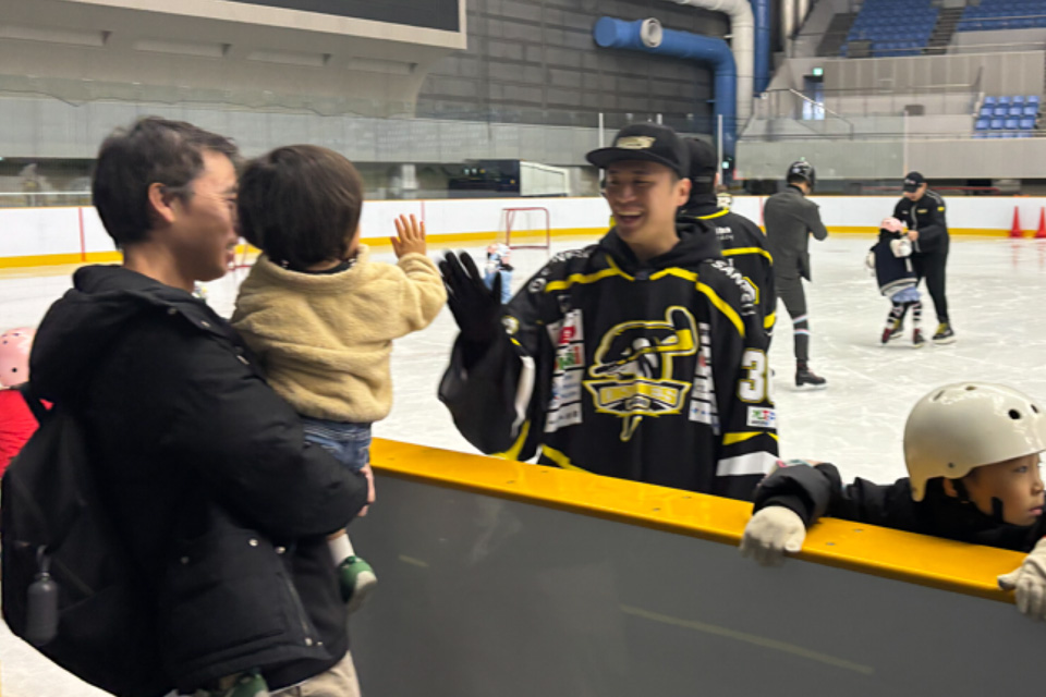 アイスホッケー体験教室でリンク外の子どもと選手が交流する様子