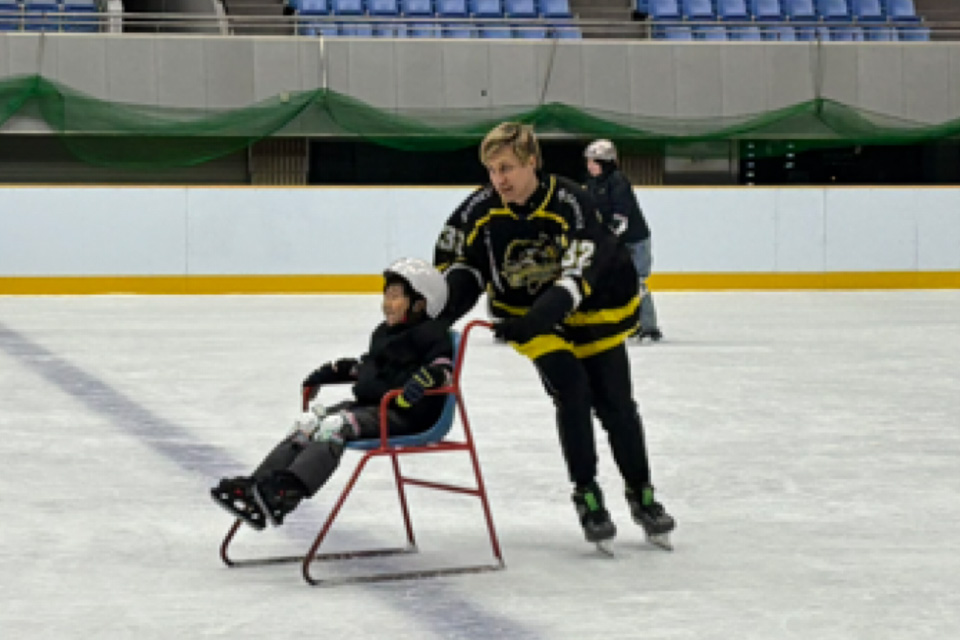 選手が子どもが乗ったソリを押す様子