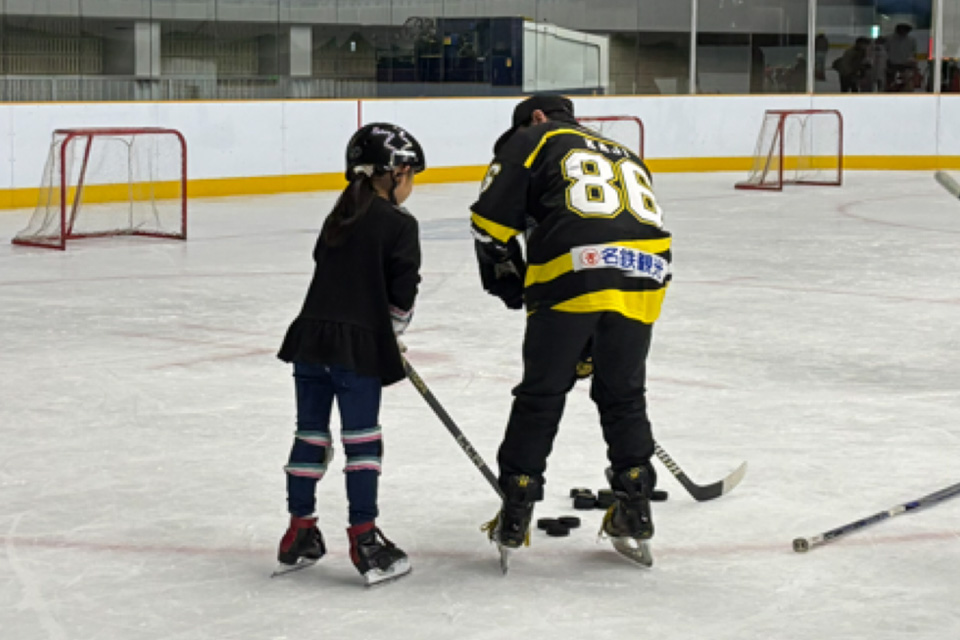 選手が子供にシュートの打ち方を教える様子