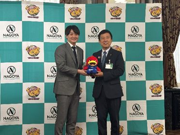 笹山キャプテンから広沢市長にマスコットキャラクターであるリードくんのぬいぐるみが手渡された様子