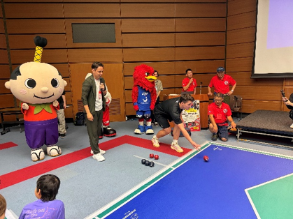 名古屋ダイヤモンドドルフィンズのジェイク 幸輝・ホルツ選手がボッチャ体験をしている様子
